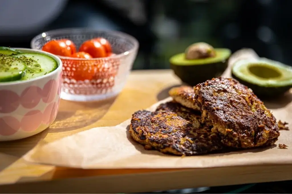 Ketopihvit ja vihanneksia taustalla.